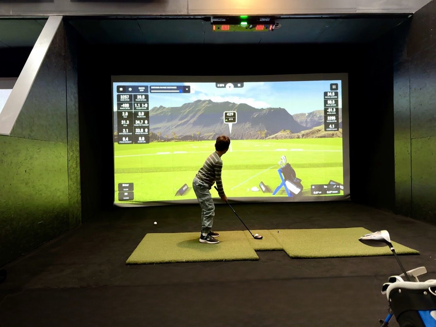 Junior golfer practicing on a simulator bay at COR Golf