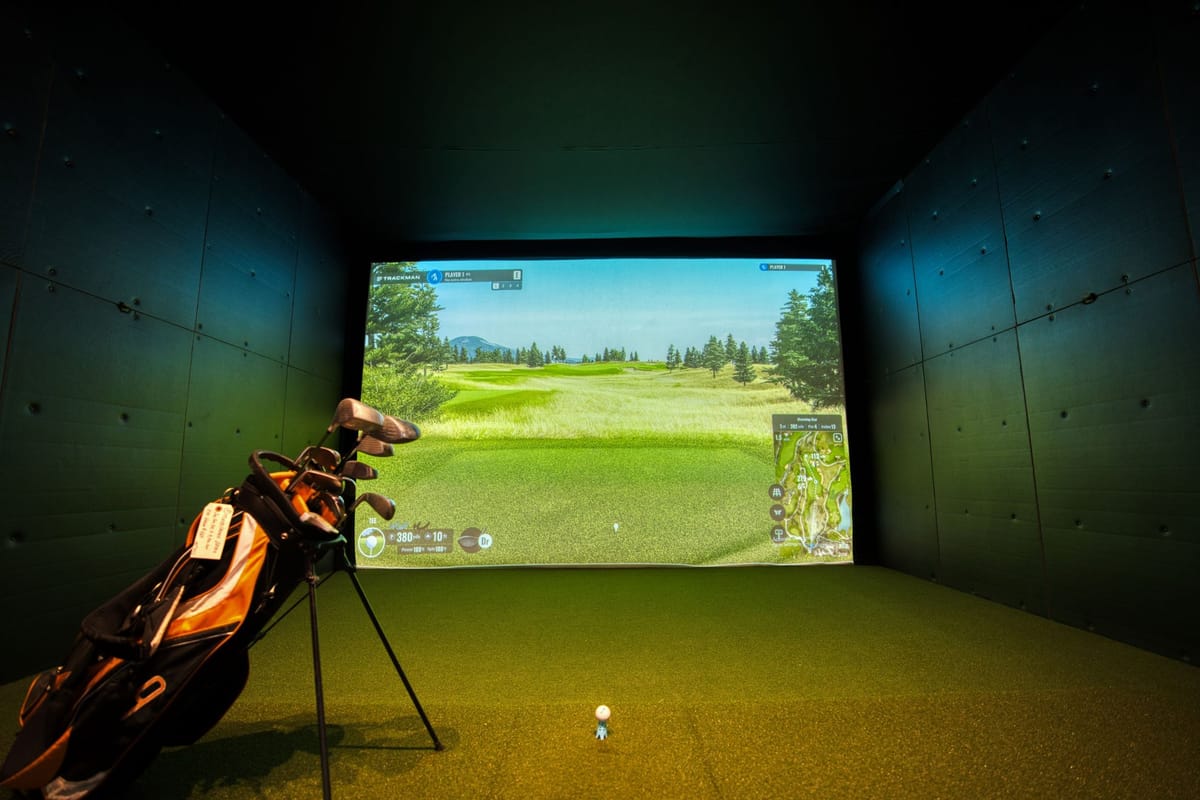 Indoor golf simulator bay with projection screen